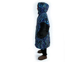 Woman wearing oversized blue rain Aboriginal art hooded blanket with sherpa lining and front pocket