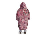 Woman wearing pink oversized hooded blanket with Indigenous aboriginal inspired artwork and plush fleece lining
