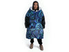 Woman wearing oversized blue rain Aboriginal art hooded blanket with sherpa lining and front pocket
