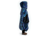 Woman wearing oversized blue rain Aboriginal art hooded blanket with sherpa lining and front pocket
