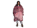 Woman wearing pink oversized hooded blanket with Indigenous aboriginal inspired artwork and plush fleece lining