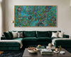 Living room with a green velvet sofa, coffee table, and colorful Luxury Indigenous Australian wall art painting on the wall.