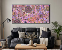 Family Day Out Aboriginal artwork displayed above a black leather lounge in a contemporary home interior.