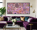Family Day Out Aboriginal painting styled above a purple lounge in a luxury interior setting.