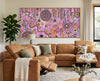 Family Day Out original painting by Kelly Taylor displayed above a warm tan sofa in a modern living room.
