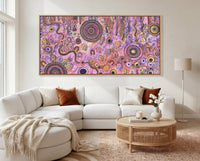 Family Day Out Aboriginal artwork displayed above a cream sofa in a bright luxury living room.