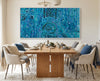 Dining room with a wooden table and chairs, and a large blue rain aboriginal art abstract painting on the wall.