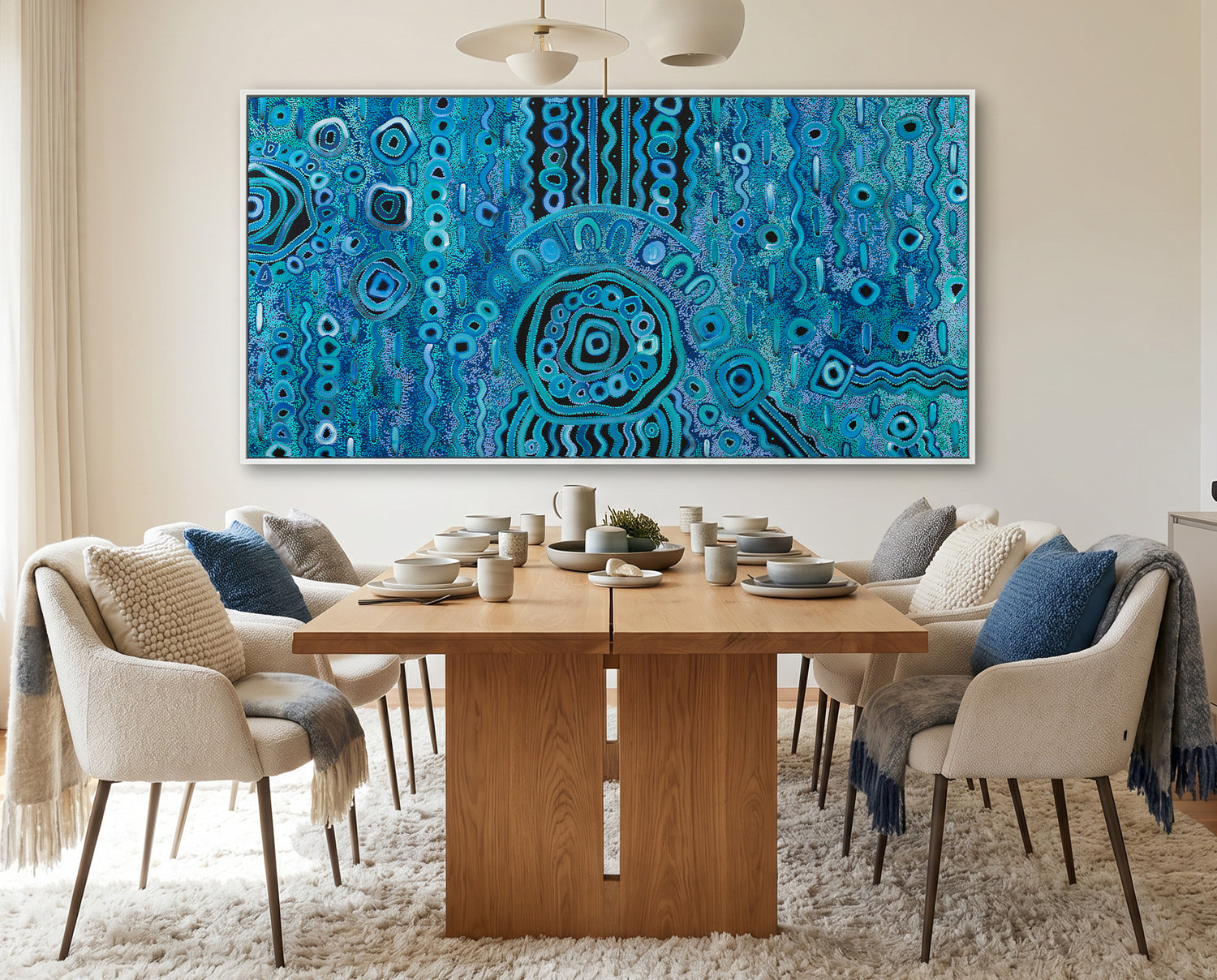 Dining room with a wooden table and chairs, and a large blue rain aboriginal art abstract painting on the wall.