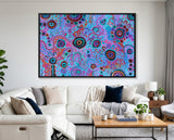 Colorful abstract art piece on a wall above a white sofa in a living room in a black float frame.