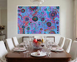 Dining room with a colorful abstract aboriginal art by T'keyah Ware painting on the wall above a set luxury dining table.