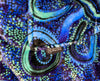 Woman wearing oversized blue rain Aboriginal art hooded blanket with sherpa lining and front pocket