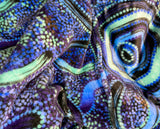 Woman wearing oversized blue rain Aboriginal art hooded blanket with sherpa lining and front pocket