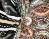 Neutral-toned oversized wearable blanket hoodie with Aboriginal-inspired pattern and front kangaroo pocket